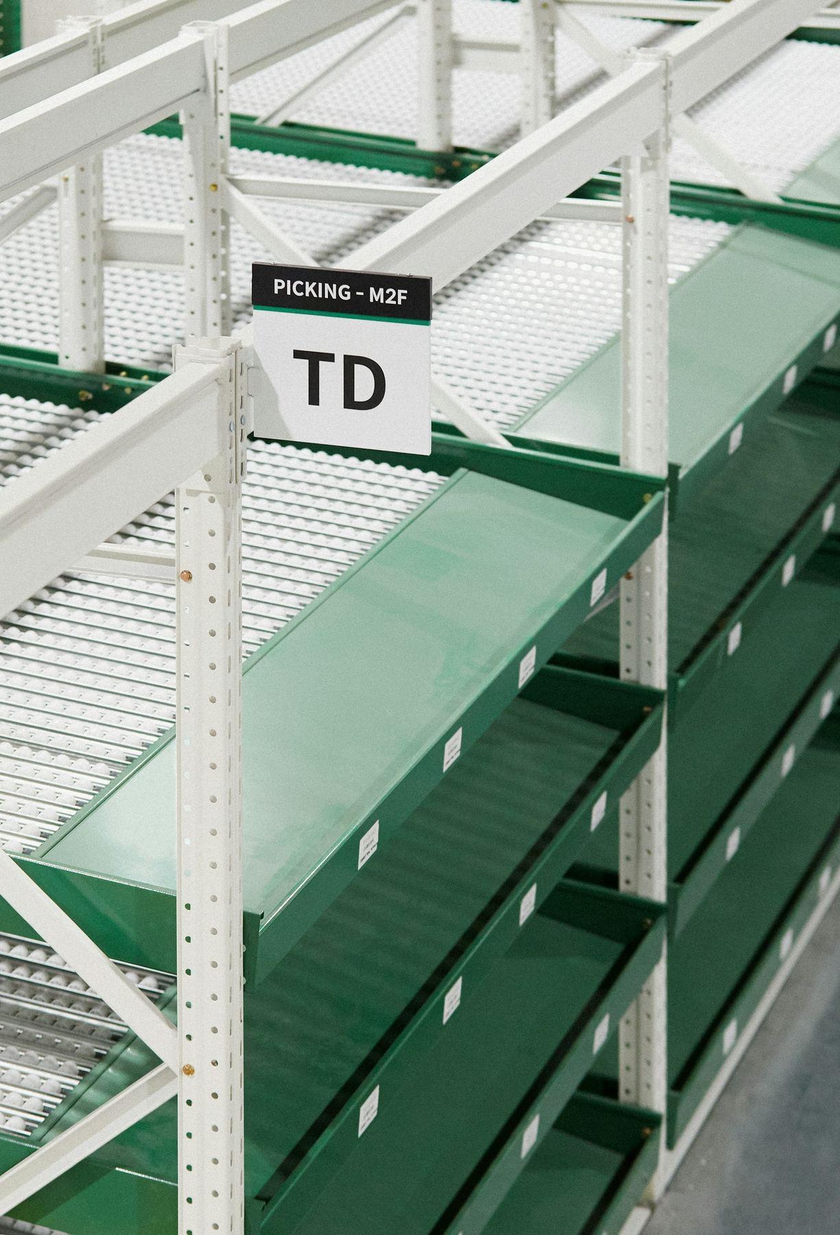 Green automated warehouse shelving and picking lanes